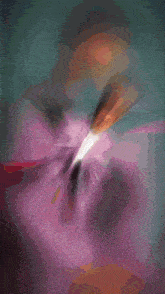 a blurry picture of a man in a purple suit with a bow tie