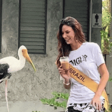 a woman wearing a sash that says brazil is drinking from a cup