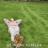 a man is laying on top of a lush green lawn with his feet in the grass .