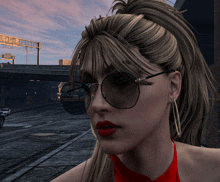 a woman wearing glasses and hoop earrings stands in front of a highway sign that says freeway