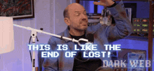 a bald man is sitting in front of a microphone and says this is like the end of lost !