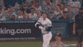 a man in a dodgers jersey stands in front of a woman in a blue dress