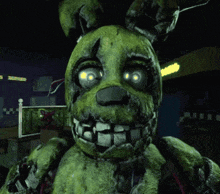 a close up of a green bunny with glowing eyes in a dark room