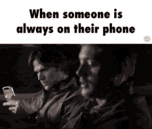when someone is always on their phone , two men are sitting in a car looking at their phones .