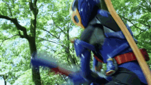 a person in a blue superhero costume is holding a sword .