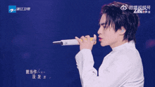 a man singing into a microphone with a purple background