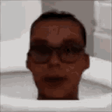 a man is sitting in a toilet with his head sticking out of it .