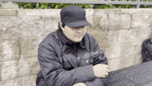 a man wearing a black hat is sitting at a table