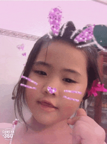 a little girl with bunny ears on her head and a camera 360 logo on the bottom