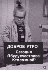 a black and white photo of a little girl wearing glasses and a bathrobe