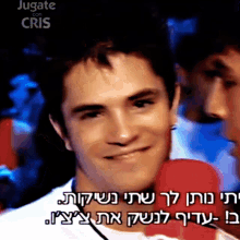 a man talking into a red microphone with the words " jugate con cris " behind him