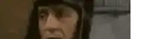 a close up of a man 's face with a hat on and a blurred background .
