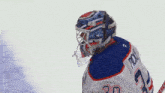 a hockey player wearing a helmet and number 30 jersey