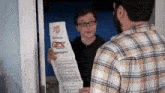 a man in a plaid shirt is holding a piece of paper that says ger contract