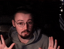 a man with a beard wearing glasses and a hoodie