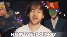 a man is asking how we doing in front of a mario hat