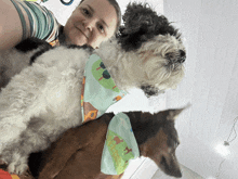 a woman holds a dog with a bandana that says ' farm ' on it