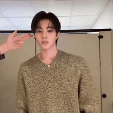 a man in a green sweater is being touched by someone