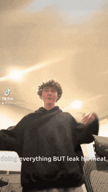 a man in a black hoodie is doing everything but leak his meat in a tiktok video