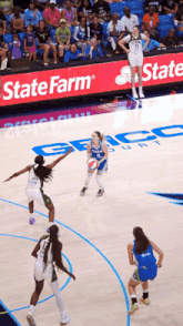 a female basketball game is being played in front of a state farm sign