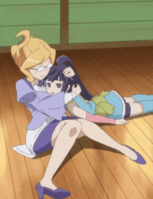 a woman sits on the floor hugging a girl