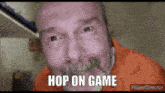 a man with a beard and an orange shirt says " hop on game "