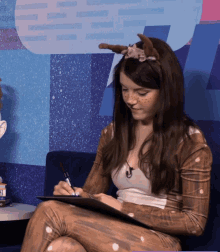 a woman in a deer costume is sitting on a couch writing on a clipboard