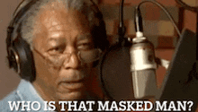 a man wearing headphones is talking into a microphone and asking who is that masked man ?