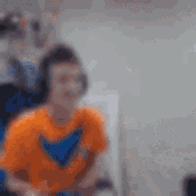 a blurry picture of a person wearing headphones and a orange shirt .