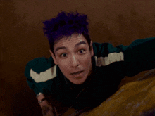 a man with purple hair is holding a spinner