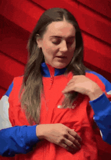 a woman wearing a red , white and blue jacket with the word ellesse on it