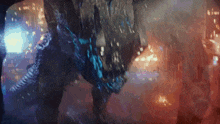 a monster is walking through a city at night with a lot of lights behind it
