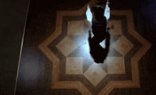 a person is standing on a wooden floor with a star pattern