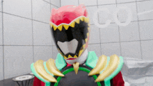 a person in a red and black costume with the word co behind them