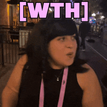 a woman in a black tank top is standing in front of a sign that says [ wth ]