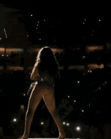 a naked woman is dancing on a stage in front of an audience