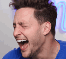 a man in a blue shirt is making a funny face