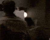 a man in a plaid shirt is opening a fridge