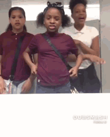 a group of young girls are standing next to each other in a bathroom and dancing .
