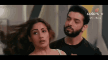a man and a woman are standing next to each other and looking at each other .