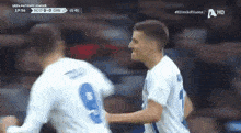 two soccer players are hugging each other during a uefa nations league game