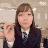 a woman in a suit and tie is making a face