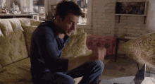 a man is sitting on a couch with a laptop