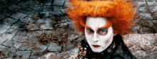 a woman with red hair and white face paint