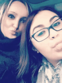 two women are posing for a picture and one has glasses