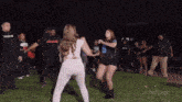 a group of people are dancing in a field and one of them is wearing a zebra shirt