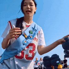 a woman wearing a number 33 jersey holds a stuffed animal