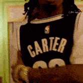 a man wearing a carter jersey is standing in a room
