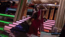 a woman in a red saree is dancing on a stage with the words colors hd at the top