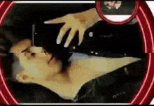 a man is laying down and taking a picture of himself with his phone .